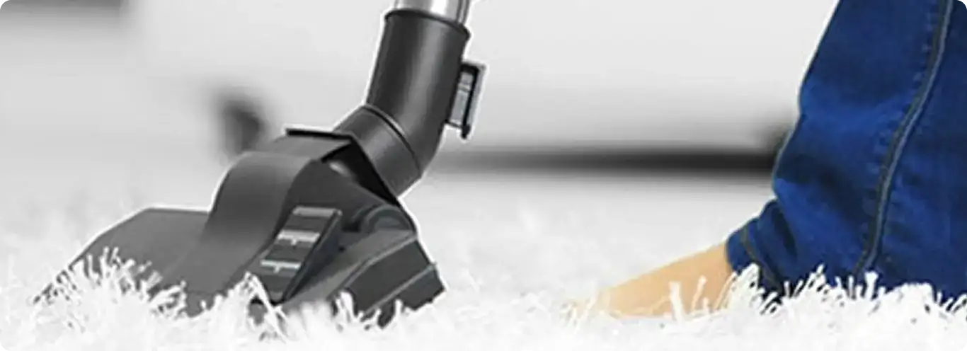Close-up of a professional vacuuming a white carpet in Collingswood.